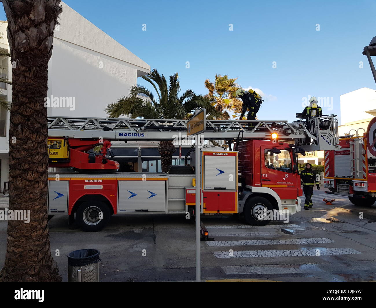 Can Picafort, Mallorca, Spain. 20th Mar, 2019. Firefighters put out fire on the roof of a building caused by a chimney, cutting the road. Credit: Sergiu Gabi Trasa/Alamy Live News Stock Photo