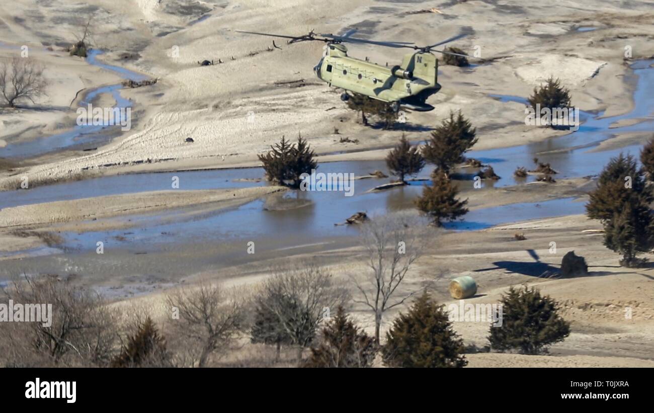 Nebraska Army National Guard soldiers unload bales of hay from a CH-47 Chinook helicopter for cattle stranded by flooding March 20, 2019 Richland, Nebraska. Historic flooding caused by rapid melting of record snowfall sweep through rural communities in Nebraska and Iowa killing at least four people in the Plains and Midwest. Stock Photo