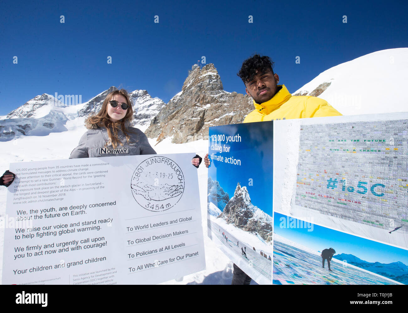 Jungfraujoch. 20th Mar, 2019. Swiss teenagers Sarangan Sivarajalingam (R) and Selma Schellenberg show copies of a postcard calling for action against climate change on the Aletsch glacier under Jungfraujoch in Switzerland, on March 20, 2019. Some 900 postcards from youths all over the world were stamped and sent on Wednesday from Europe's highest postbox on the Jungfraujoch peak, Switzerland, to global leaders, calling for action against climate change. Credit: Xu Jinquan/Xinhua/Alamy Live News Stock Photo