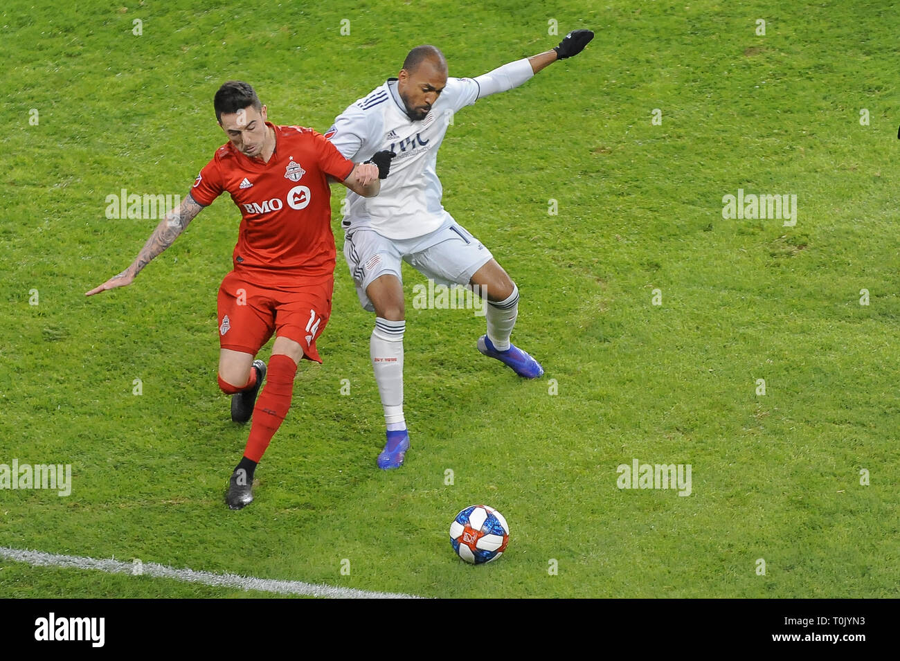 Jay Chapman (#14) and Teal Bunbury (#10) fight for the ball during 2019 MLS Regular Season match between Toronto FC (Canada) and   New England Revolution (USA) at BMO Field in Toronto. (Final Score: Toronto FC 3 - 2 New England Revolution) Stock Photo