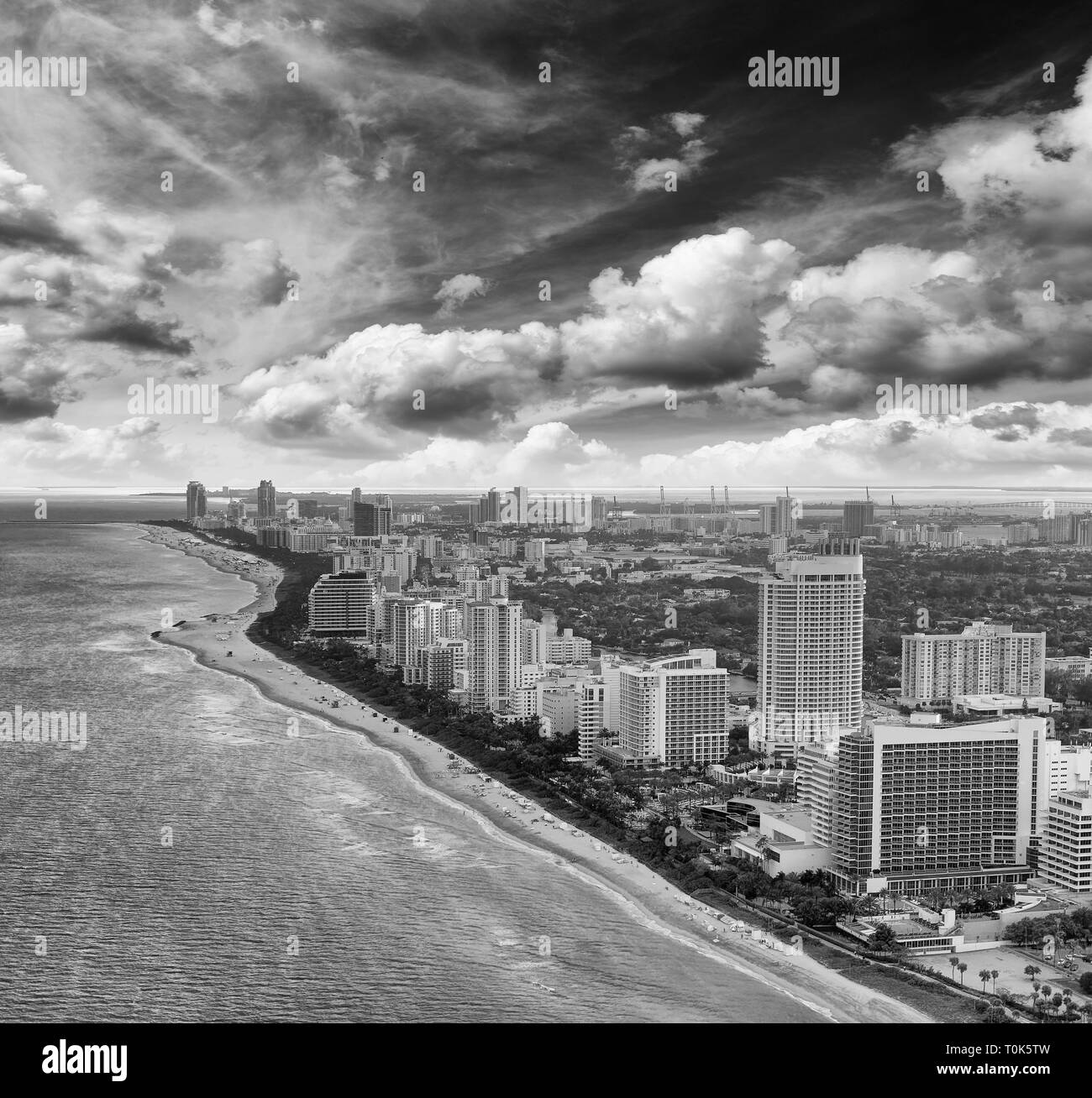 Amazing skyline of Miami Beach. Aerial view of city buildings from helicopter on a cloudy sunset. Stock Photo