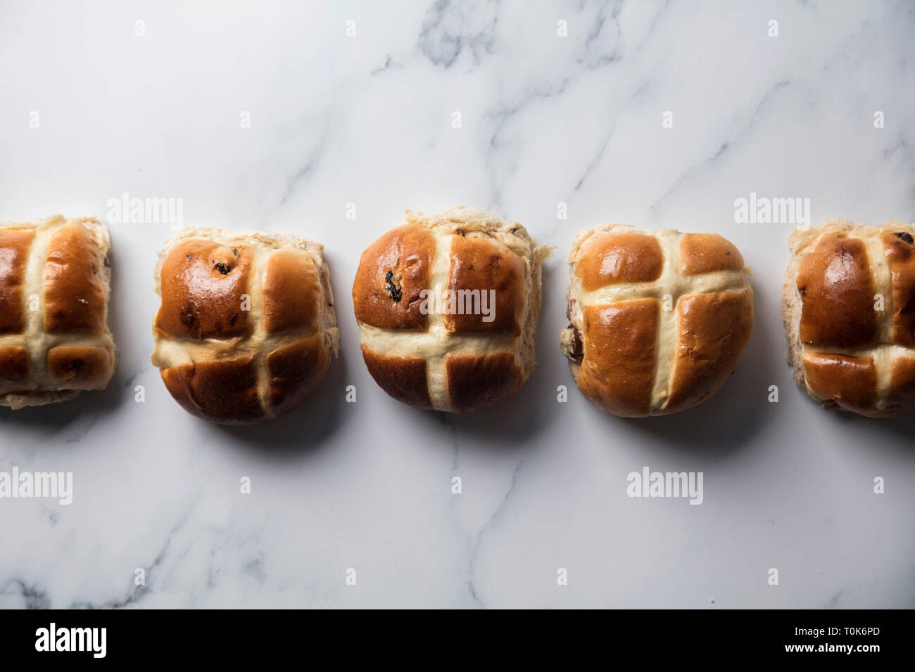 Traditional hot cross buns with raisins on a marble surface Stock Photo