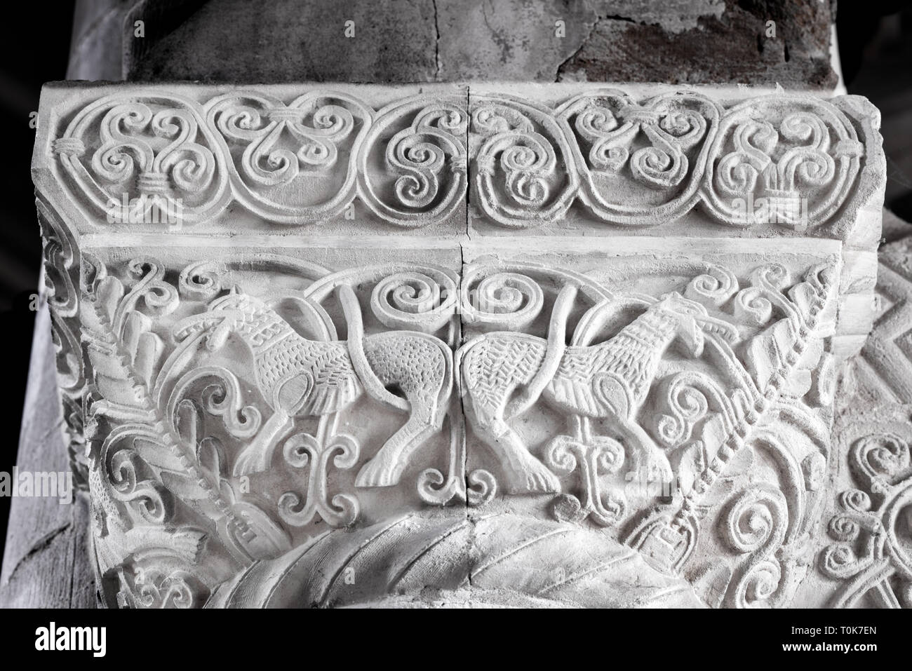 Carved, decorative stonework on the capital of a pillar at the norman built church named St Peter in Northampton, England. Stock Photo