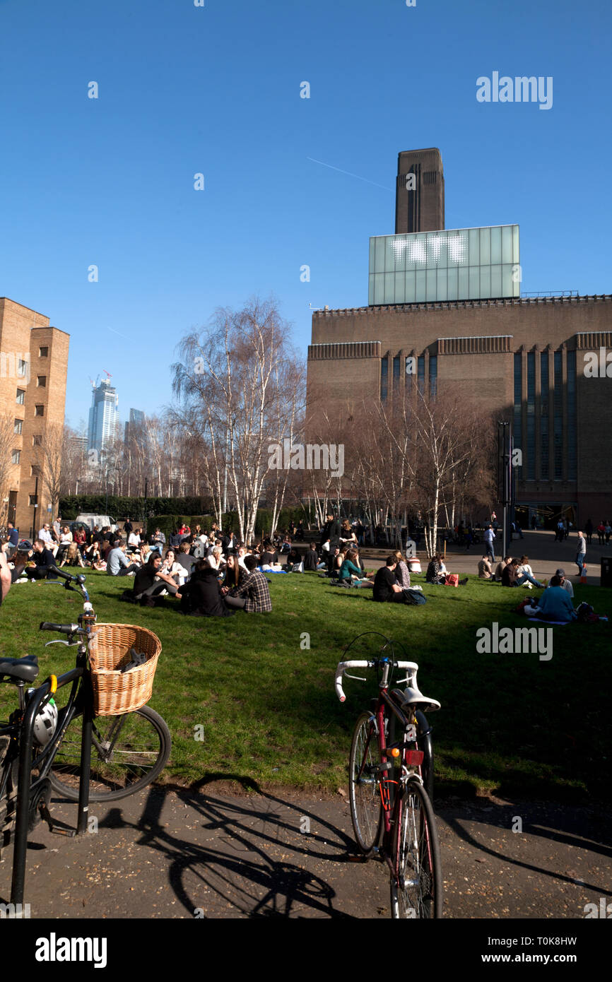 people sitting on grass otside tate modern bankside southwark london england Stock Photo