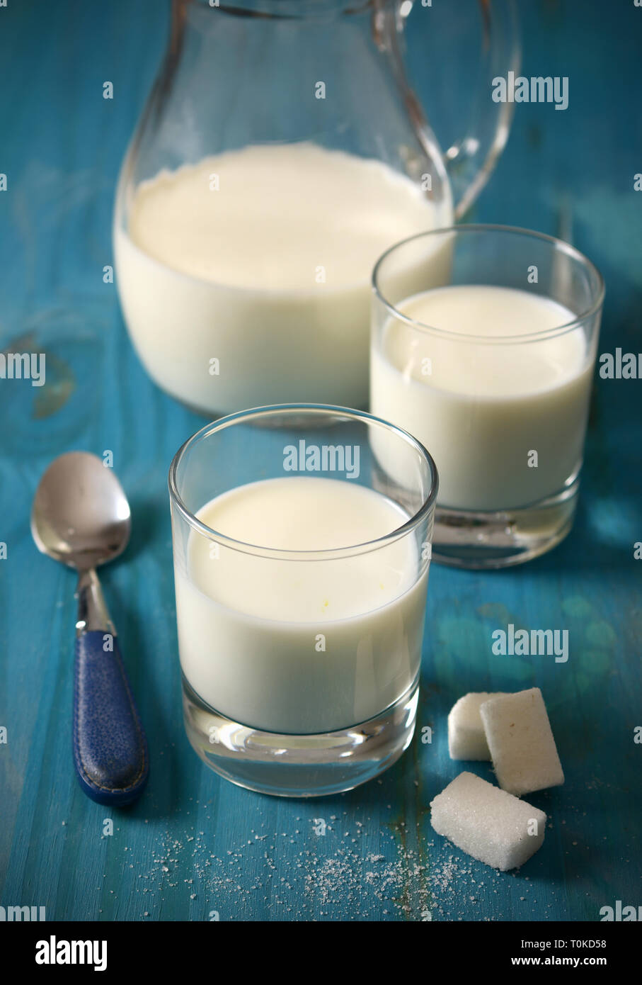 fresh milk in glasses with sugar cubes - closeup Stock Photo