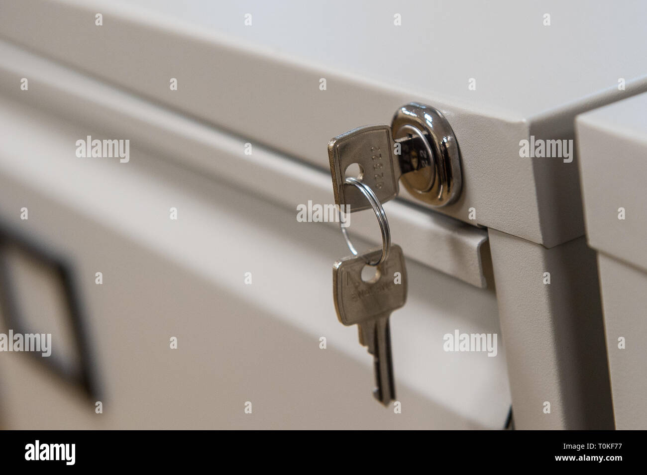 Detail of beige filing cabinet with key or keys Stock Photo