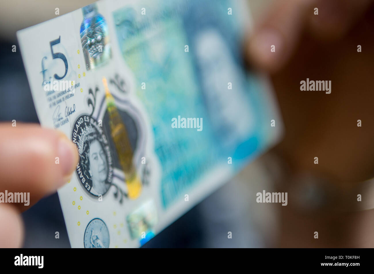 Hands holding British 5 five pound note Stock Photo