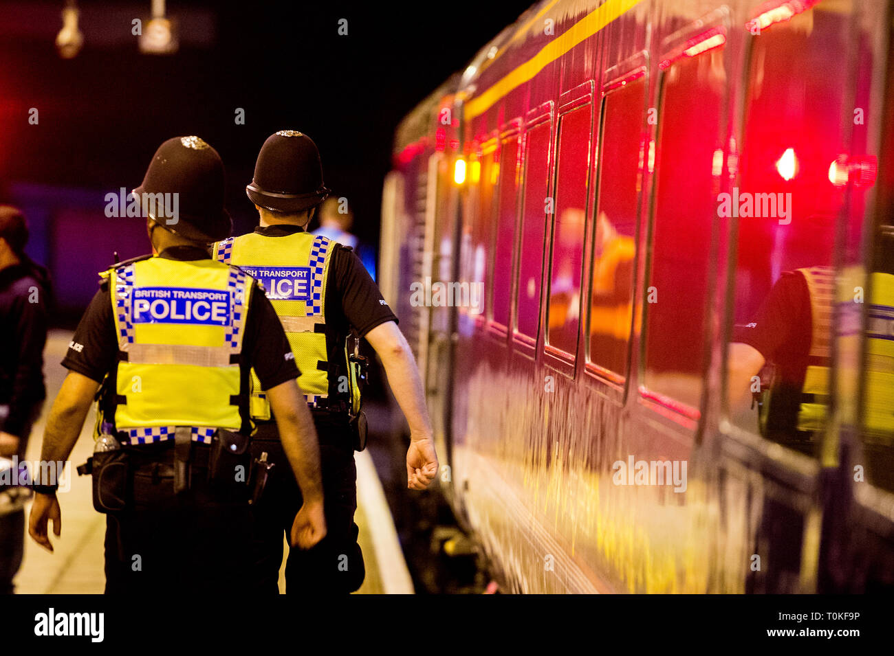 British transport Police in uniform walk along side a train Stock Photo