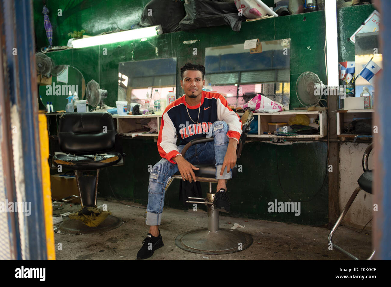 Young latino man waiting for clients at his hairdresser salon. Panama City, Panama, Central America. Oct 2018 Stock Photo