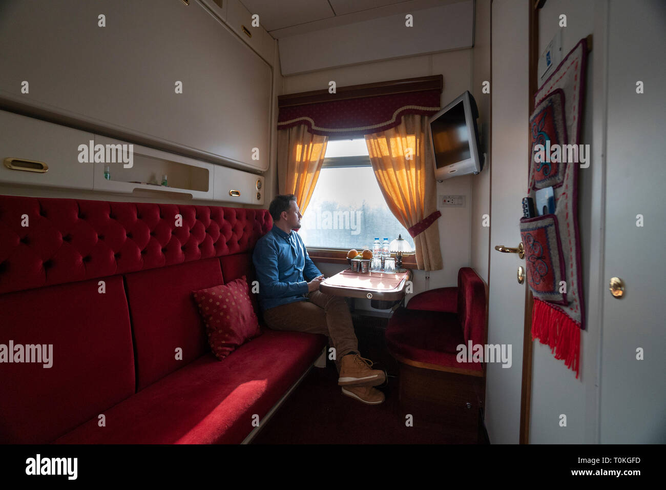 Trans-Siberian railway in winter, man sitting in train looking out of window, Russia Stock Photo
