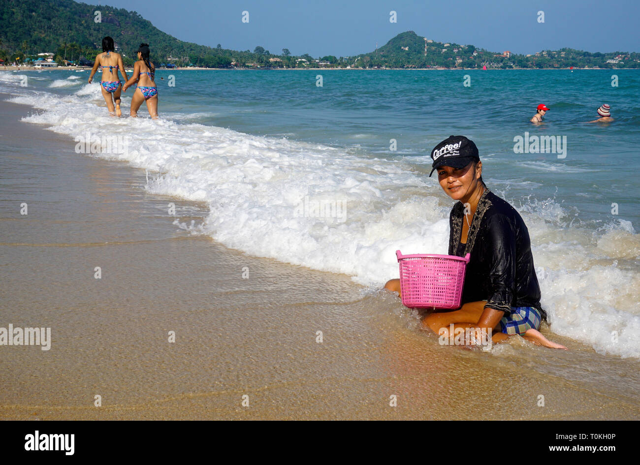 Thai woman digging for mussels at the beach, Lamai Beach, Koh Samui, Gulf of Thailand, Thailand Stock Photo