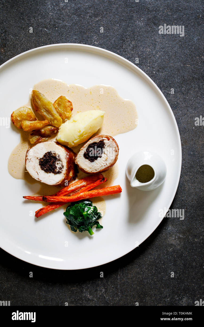 Chicken balmoral stuffed with black pudding, carrots, spinach and jerusalem artichokes Stock Chicken balmoral stuffed with black pudding, carrots, spinach and jerusalem artichokes Stock