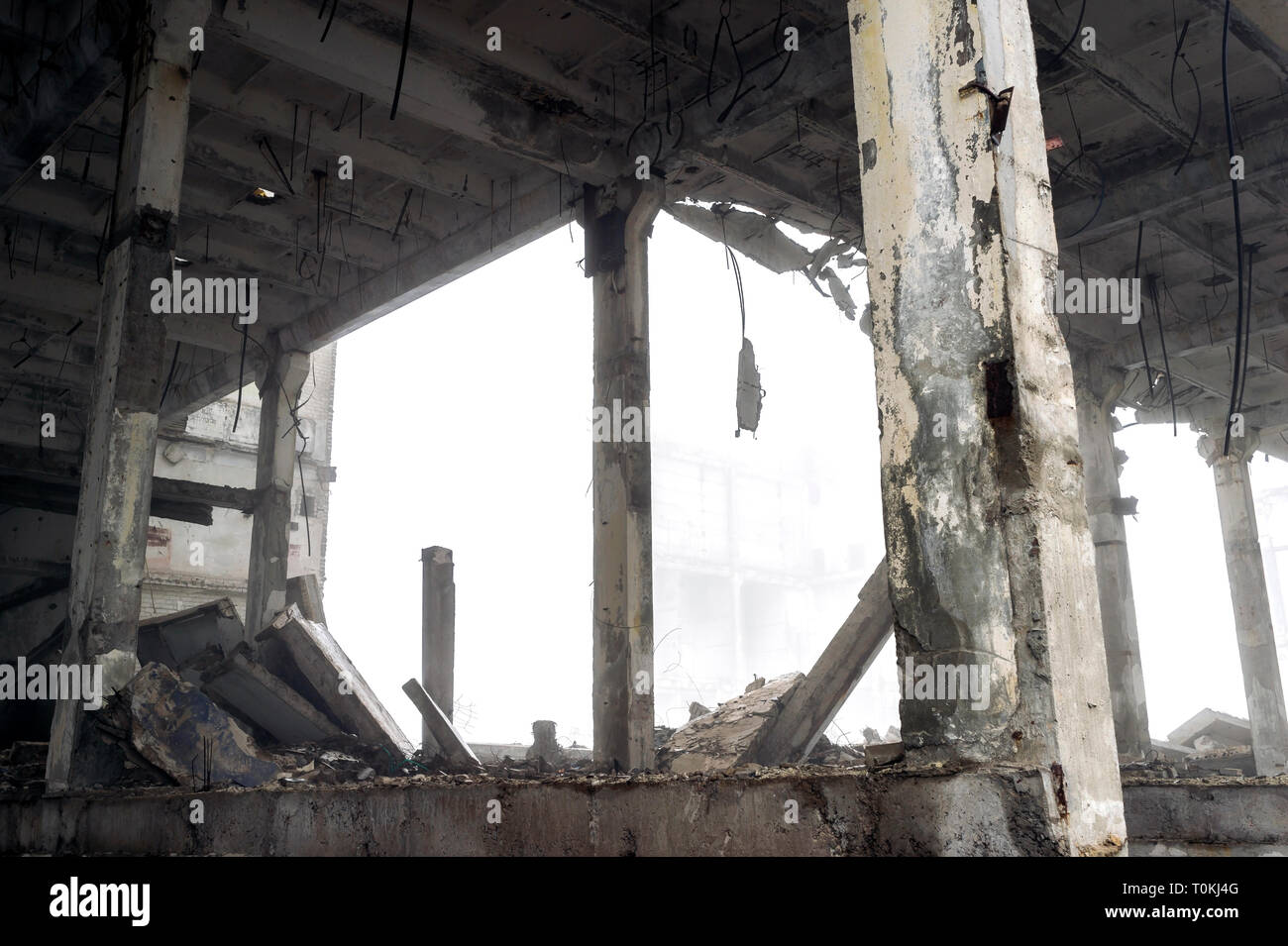 The remains of a large building destroyed in a foggy haze. Concrete ...