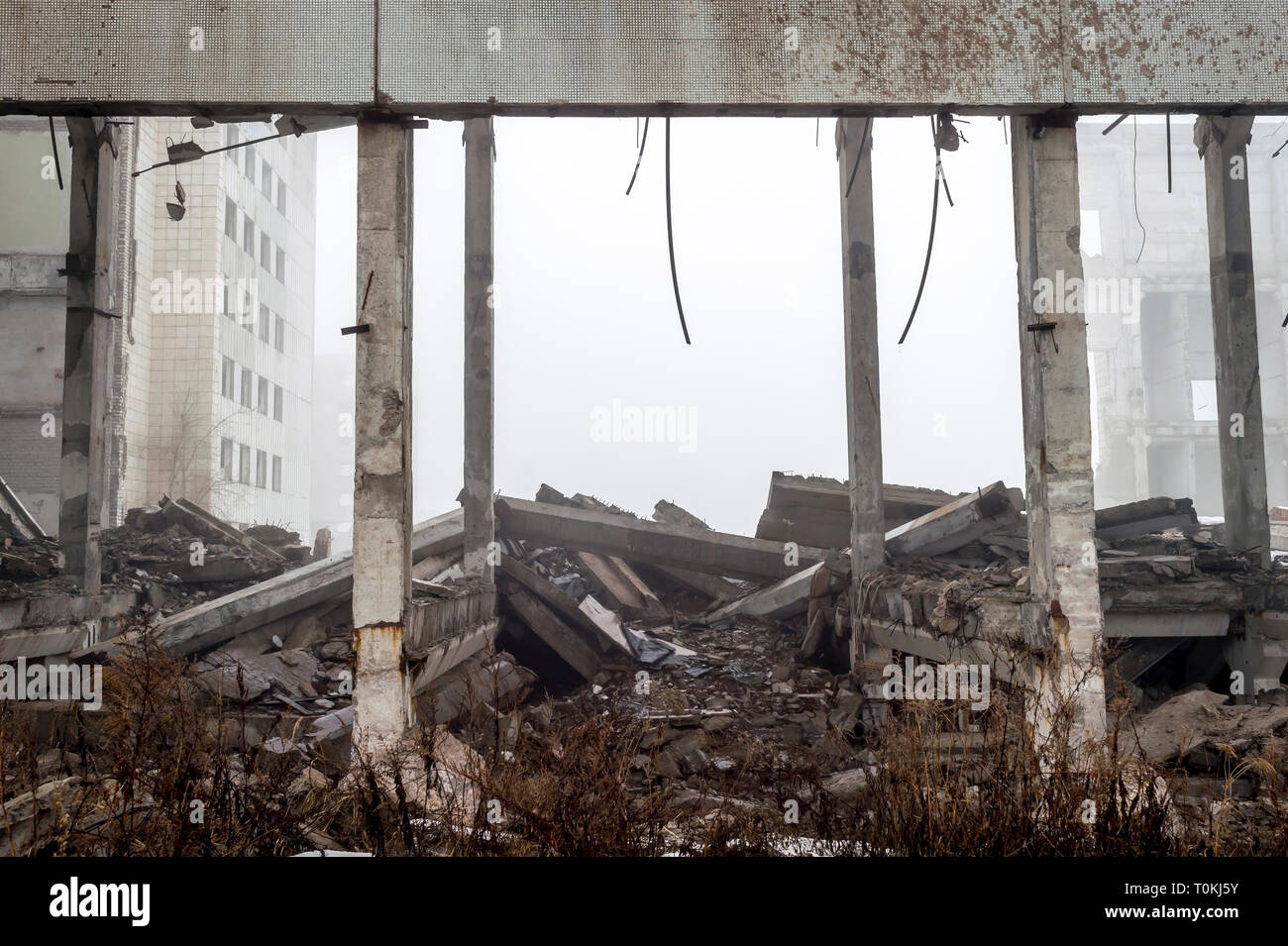 The remains of a large building destroyed in a foggy haze. Concrete ...