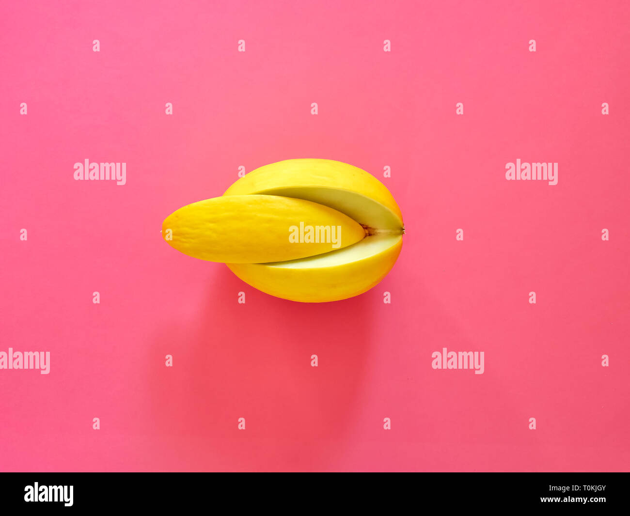 Yellow Melon Fruit isolated in fucsia background viewed from above - flatlay look - Image Minimalism concept Stock Photo