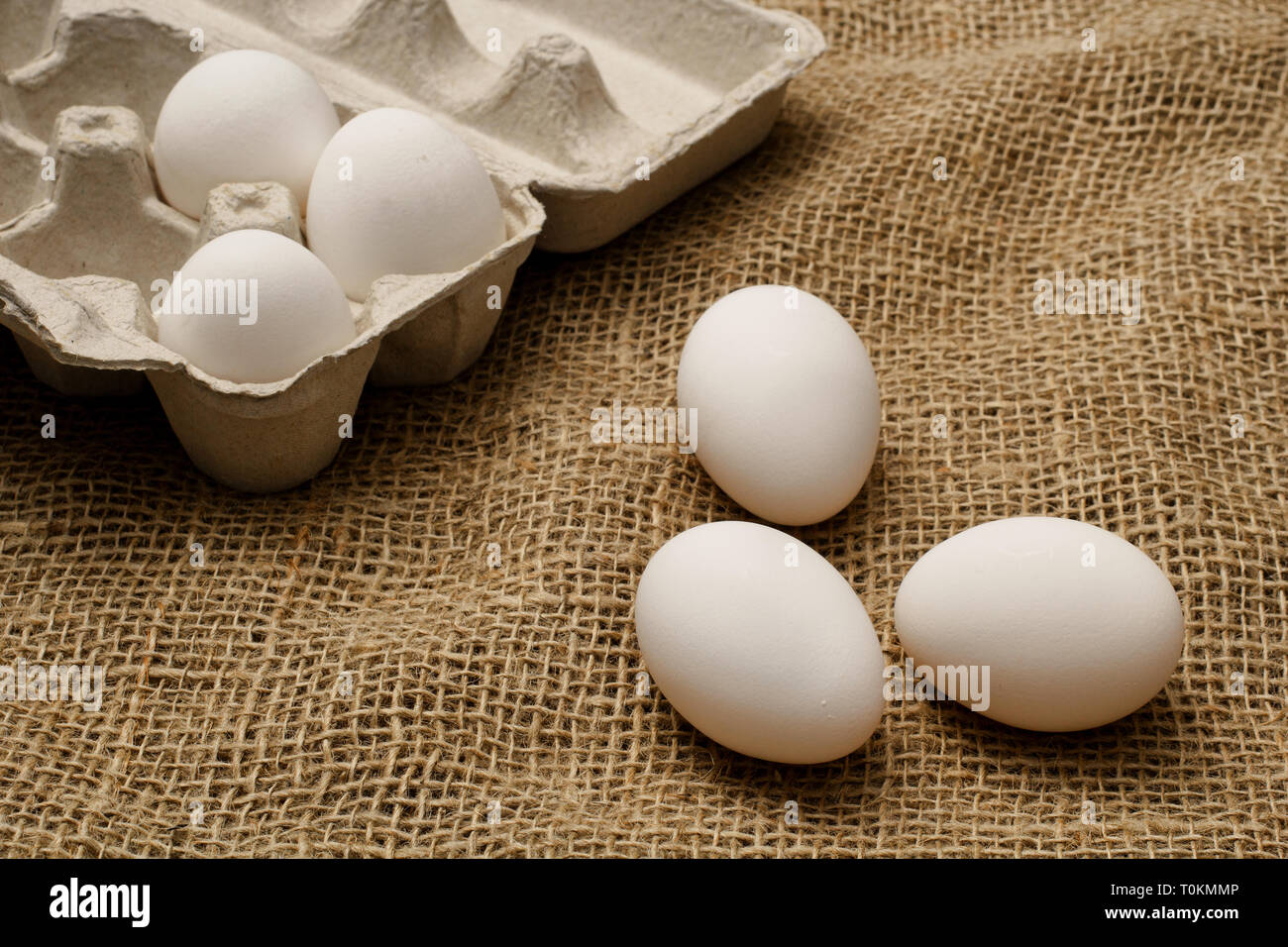 Eggs and egg carton on burlap sack cloth Stock Photo - Alamy