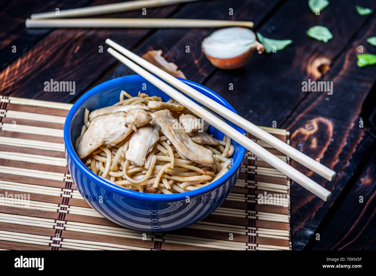Traditional asian or chines noodles with chicken meat on bowl with chopsticks on wood table Stock Photo