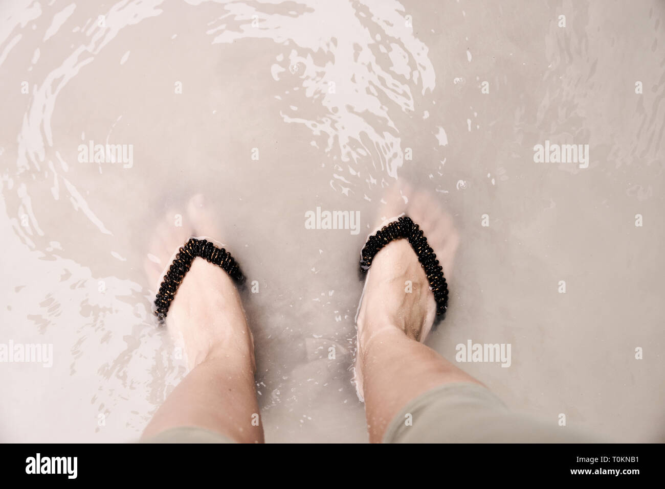 Woman standing in a puddle Stock Photo