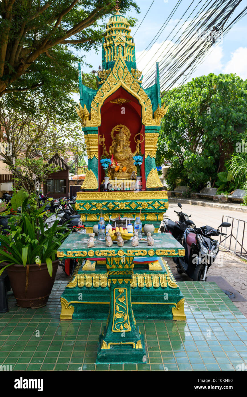 Abandoned yellow-green house of the spirit. House spirit style Thailand on the street under the trees. Stock Photo
