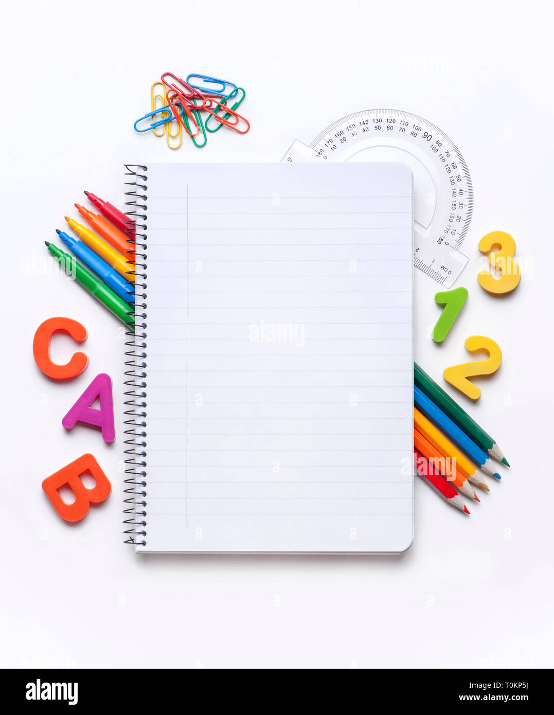 Blank notebook surrounded by a border of various school supplies Stock Photo