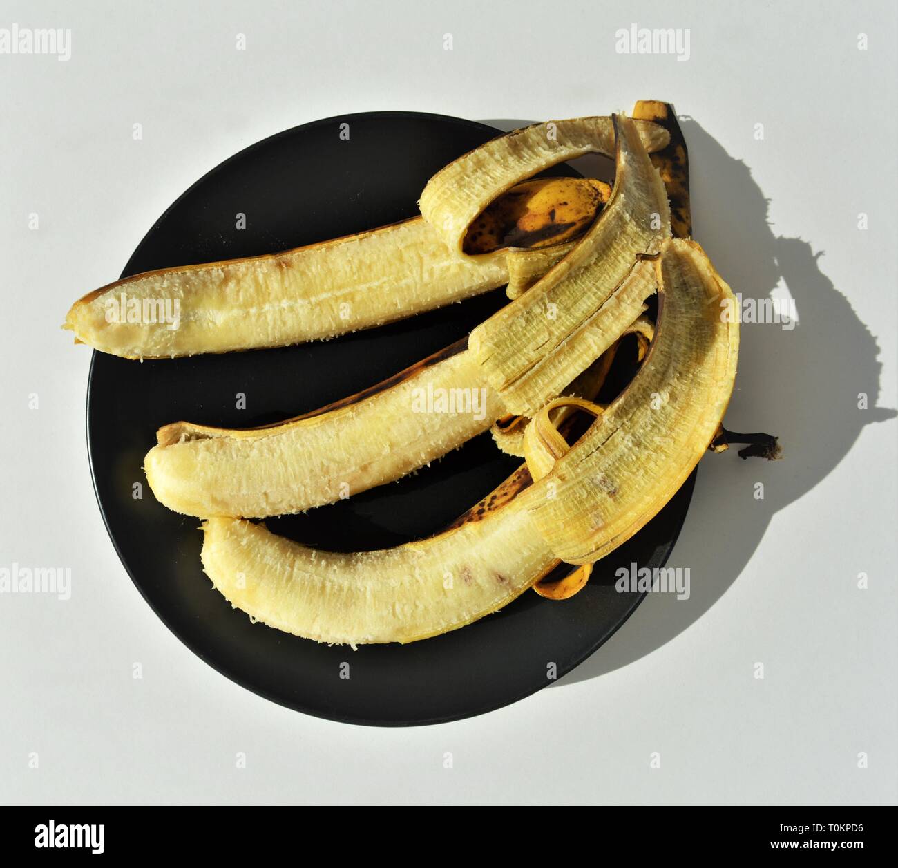 3 over ripe bananas on black plate Stock Photo