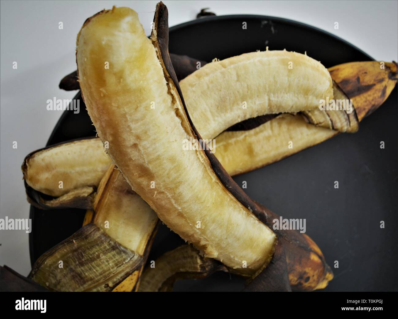 3 over ripe bananas on black plate Stock Photo