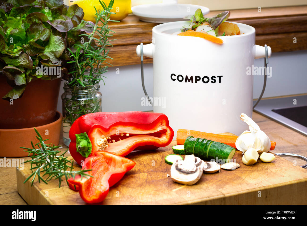 Food waste recycling kitchen, food waste from food preparation collected for recycling in kitchen compost collecting container with chopped vegetables Stock Photo