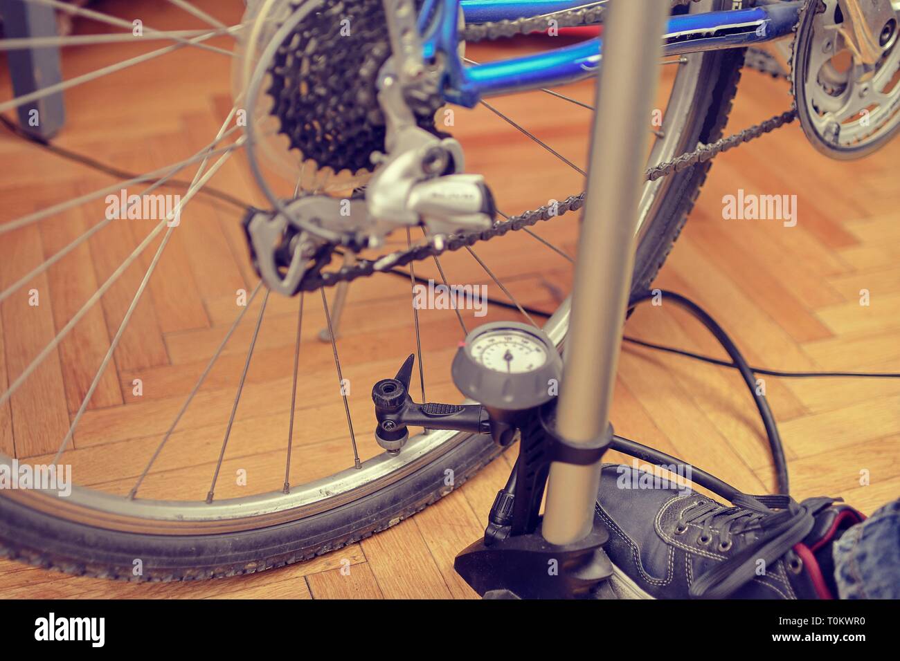 Inflating the tire of a bicycle. Pumping air into a wheel of bike. Home