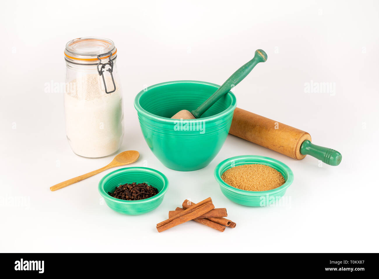 Baking Ingredients with Vintage Fiesta Ware Bowls and Antique Rolling Pin. Cinnamon, Organic Sugar, Wheat Flour in Glass Jar. Wooden Spoon. Stock Photo