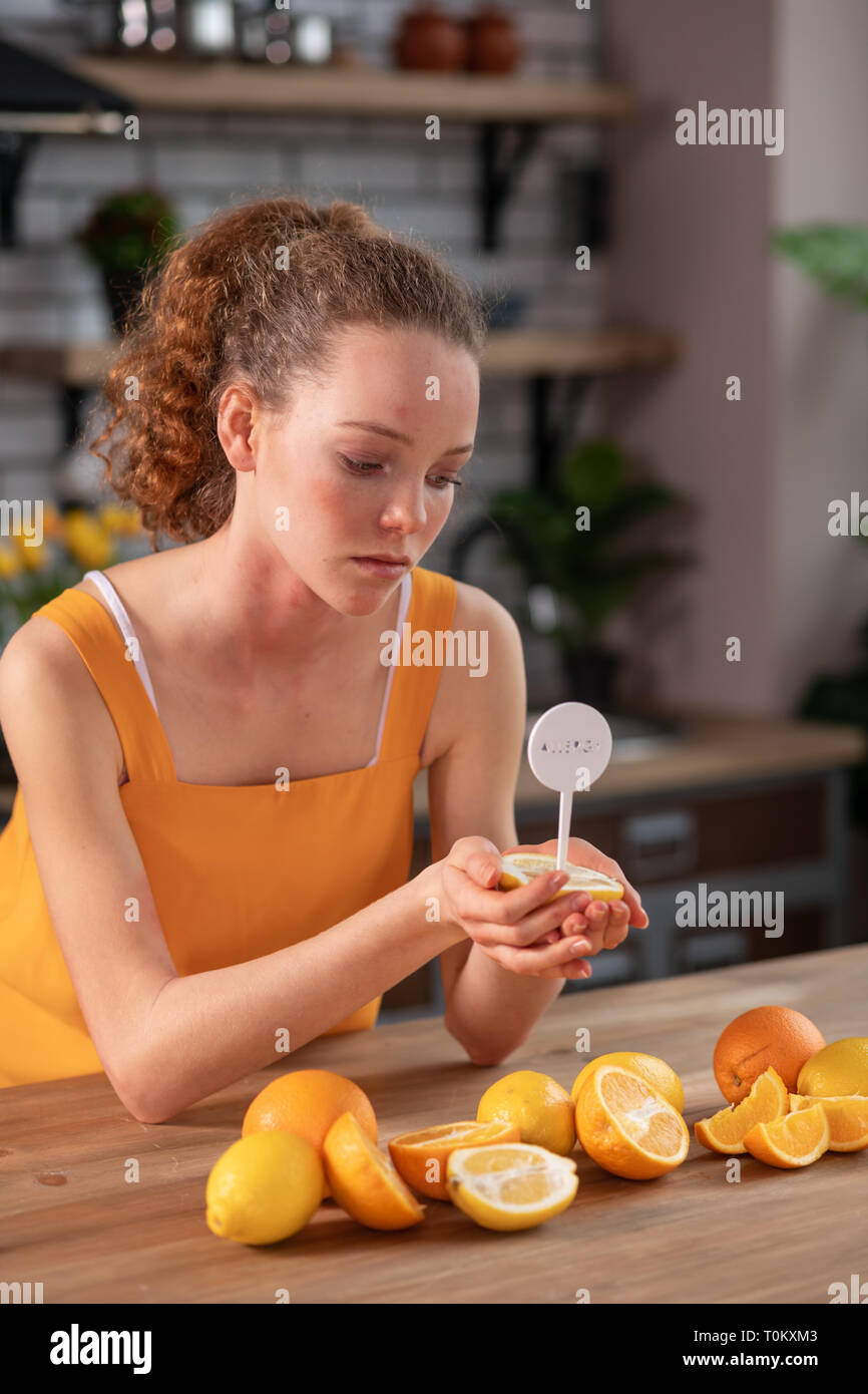 Long-haired curly girl carrying half of lemon with notification stick in Stock Photo