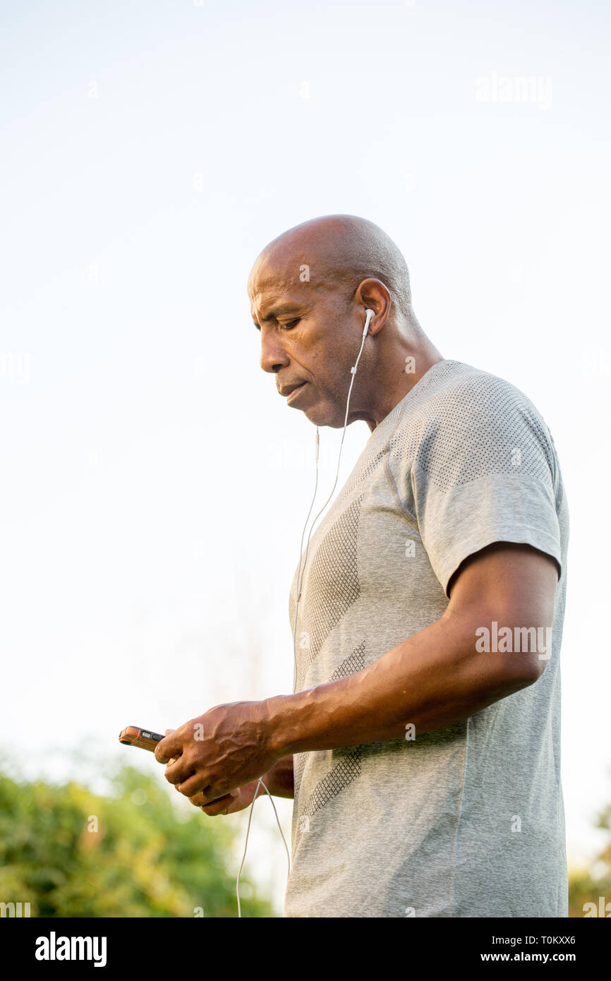 Mature fit African American man listening to music Stock Photo - Alamy