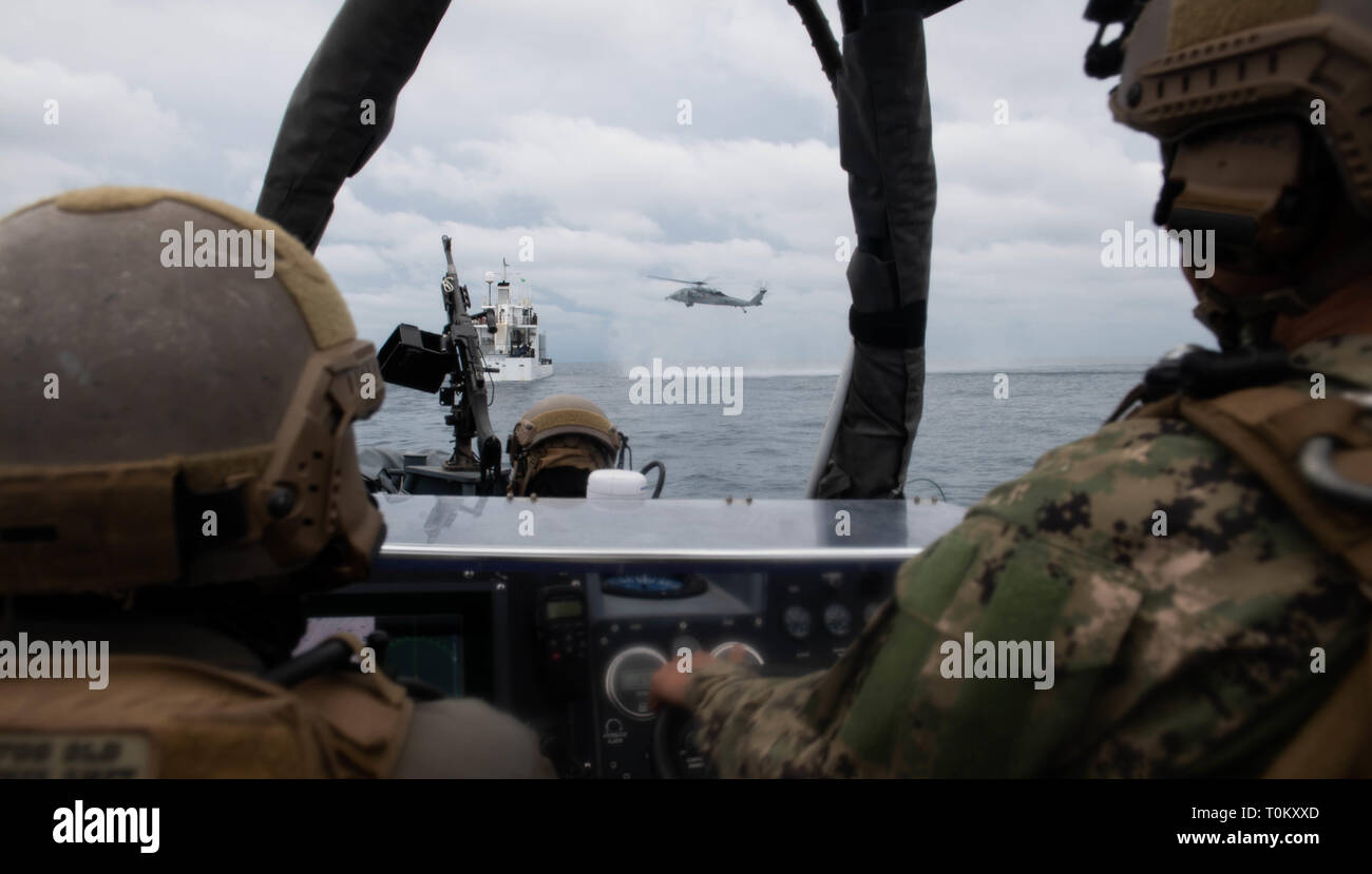 190319-N-HD110-0669  PACIFIC OCEAN (March 19, 2019) Sailors attached to Assault Craft Unit (ACU) 1 observe an MH-60S Sea Hawk Helicopter approach motor vessel MV ATLS-9701 during a visit, board, search, and seizure exercise conducted by the Harpers Ferry-class amphibious dock landing ship USS Harpers Ferry (LSD 49). Harpers Ferry is underway conducting routine operations as a part of USS Boxer Amphibious Ready Group (ARG) in the eastern Pacific Ocean. (U.S. Navy photo by Mass Communication Specialist 3rd Class Danielle A. Baker) Stock Photo