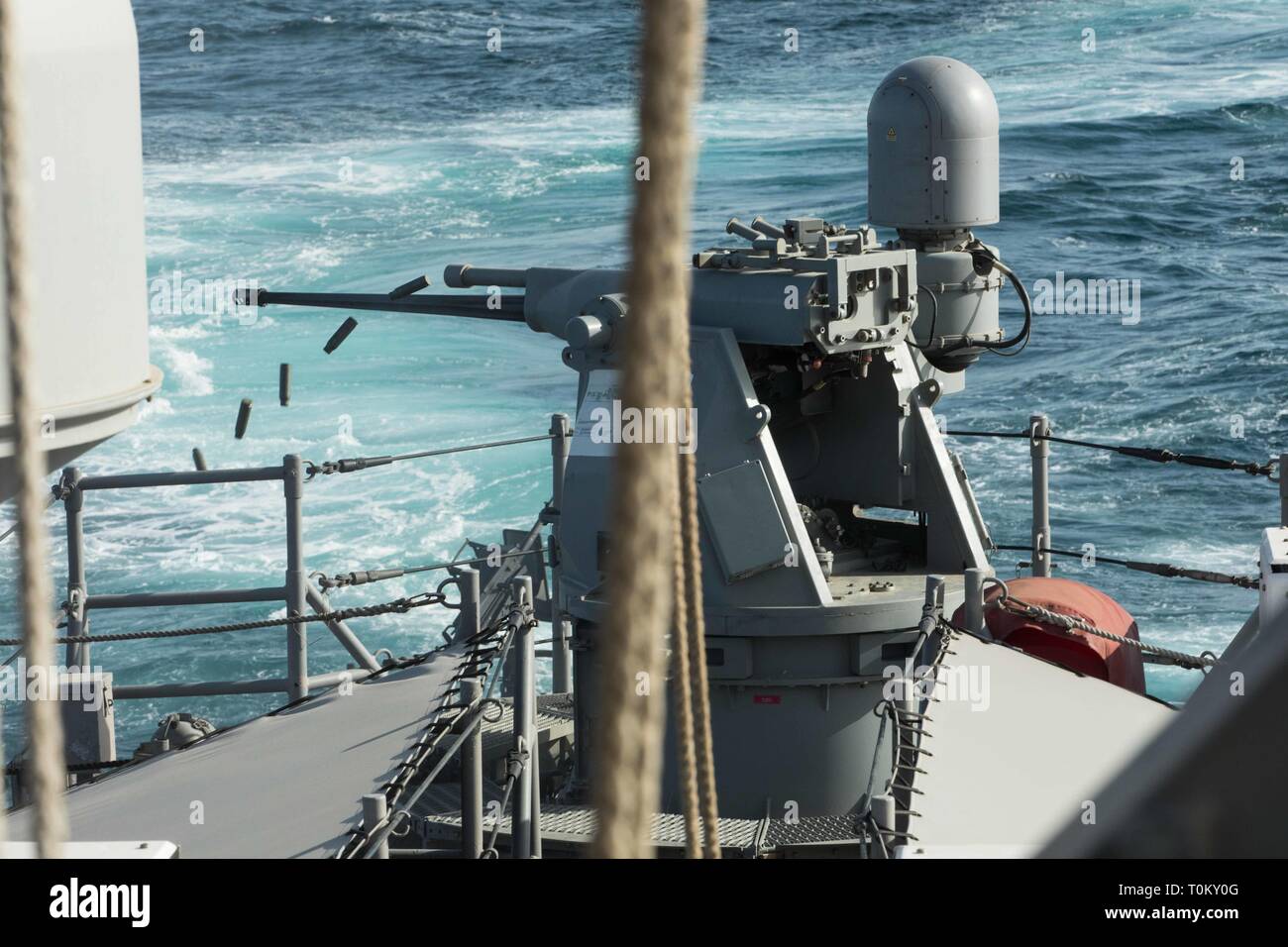 ARABIAN GULF (March 18, 2019) The Mark 38 .25mm machine gun fires toward a floating target during a gunnery exercise aboard the Cyclone-class coastal patrol ship USS Thunderbolt (PC 12). Thunderbolt is forward deployed to the U.S. 5th Fleet area of operations to ensure maritime stability and security in the Central Region, connecting the Mediterranean and the Pacific through the western Indian Ocean and three strategic choke points.  (U.S. Army photo by 1st Lt. Nicholas Zehrung/ Released) Stock Photo