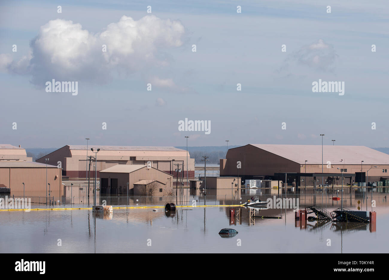Contracted employees of the Environmental Restoration, LLC company deploy a spill containment boom around the Offutt Air Force Base fuel storage area as a precautionary measure March 18, 2019 following flooding of the southeast portion of the base. An increase in water levels of surrounding rivers and waterways caused by record-setting snowfall over the winter in addition to a large drop in air pressure caused widespread flooding across the state of Nebraska. (U.S. Air Force photo by Delanie Stafford) Stock Photo