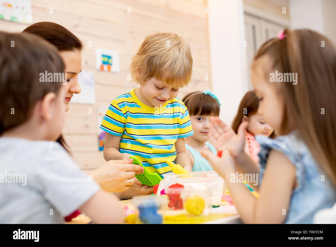 Teacher teaches kids modeling clay in playroom at daycare or kindergarten Stock Photo Alamy