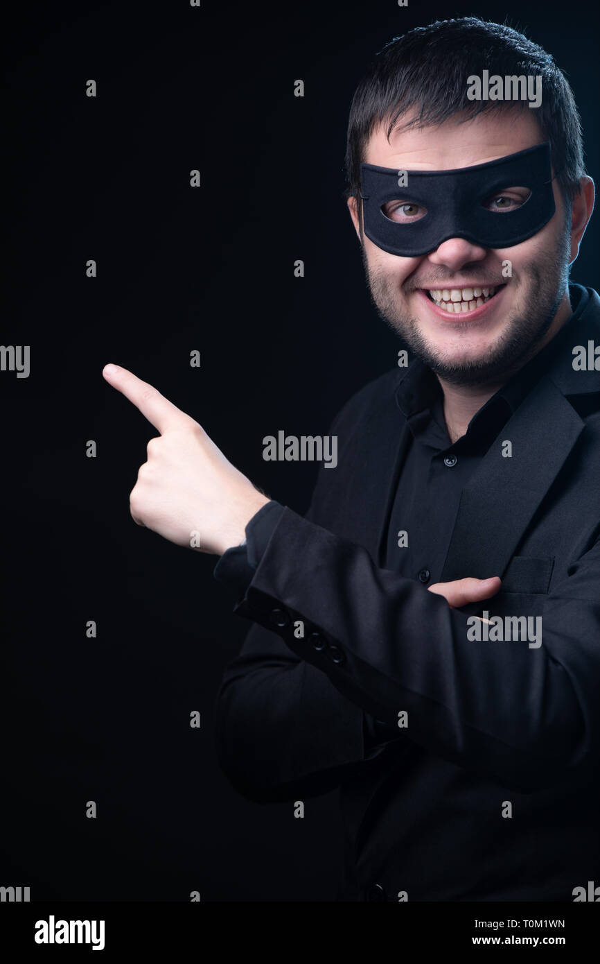 Man in black mask, jacket on empty black background Stock Photo Alamy