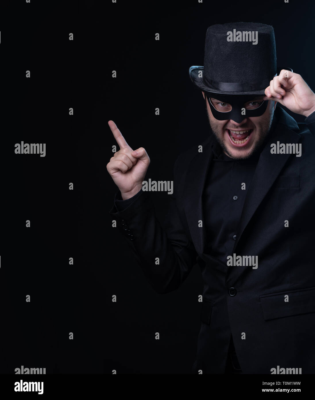 Man in black mask, jacket,hat on empty black background Stock Photo Alamy