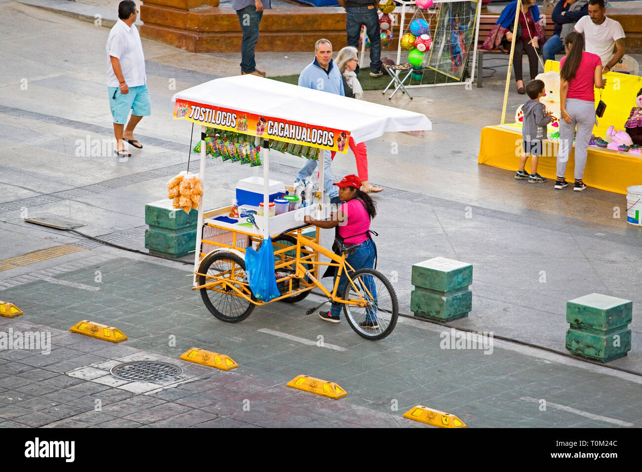 A Mexican food vendor pushes her cart down the Malecon in La Paz, Baja, Mexico Stock Photo
