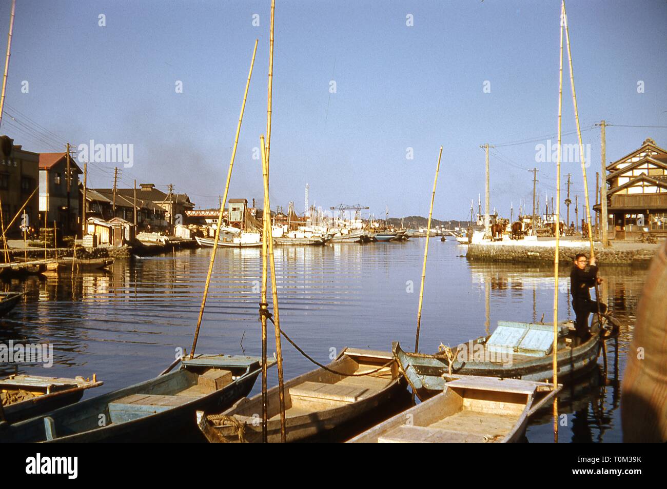 A fisherman stands on a small boat, holding a pole, on a sunny day in a  crowded marina near Matsushima Bay, Matsushima, Miyagi Prefecture, Japan,  1955 Stock Photo - Alamy