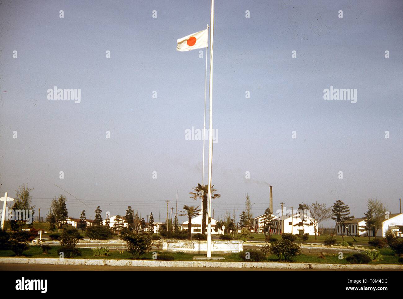 Wide shot of a military headquarters, on a sunny day, with a Japanese flag flying from a centrally placed pole, Camp Schimmelpfennig, Sendai, Miyagi Prefecture, Japan, 1952. () Stock Photo