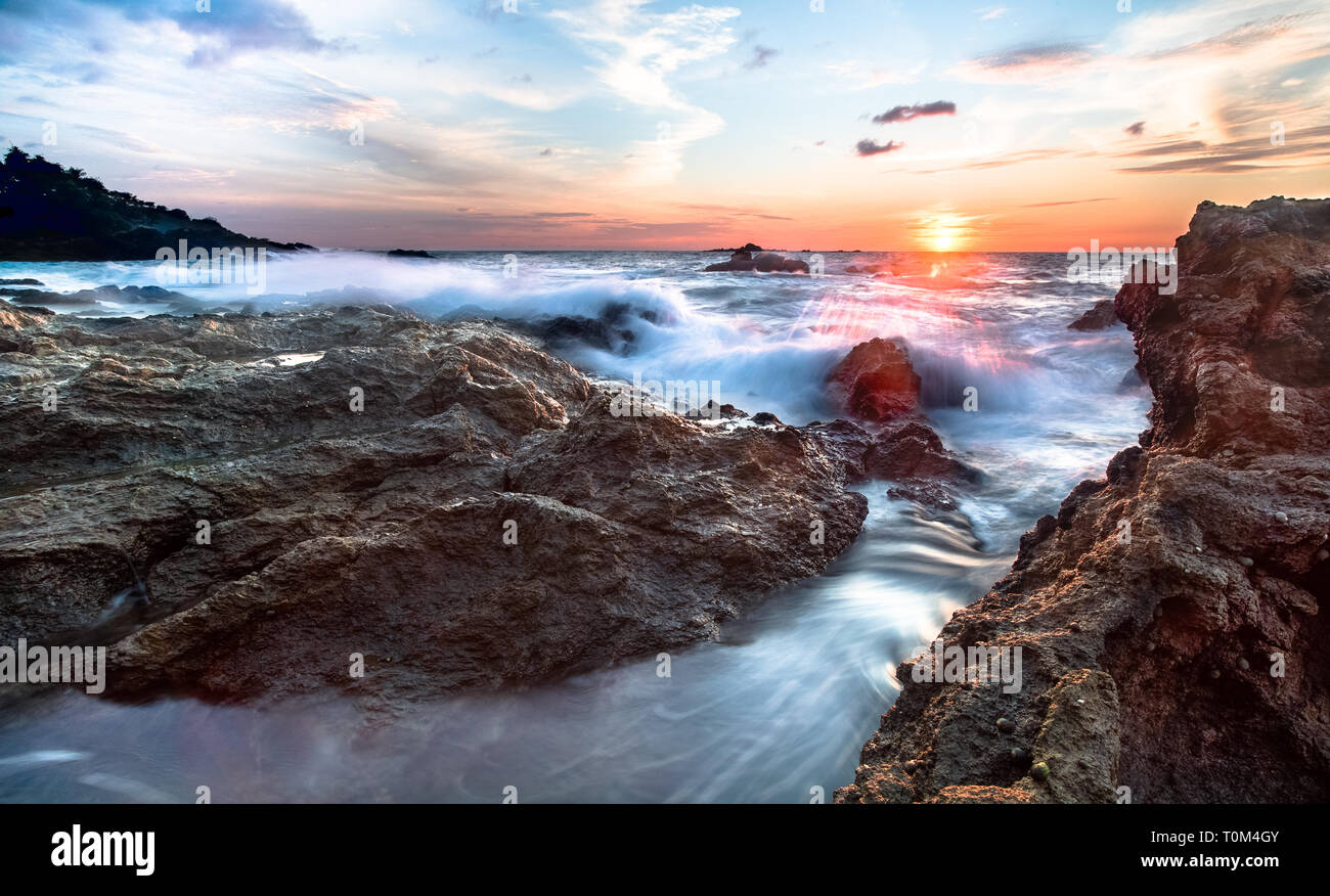 Long exposure at sunset of waves crashing on the west side of the Osa Peninsula, Costa Rica. Stock Photo