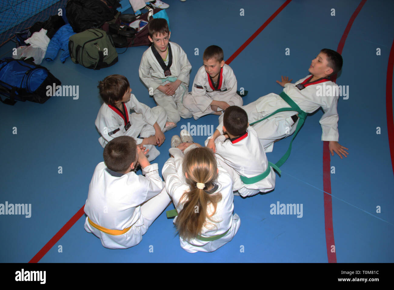 A group of taekwondo sitting on the floor for a rest. Stock Photo