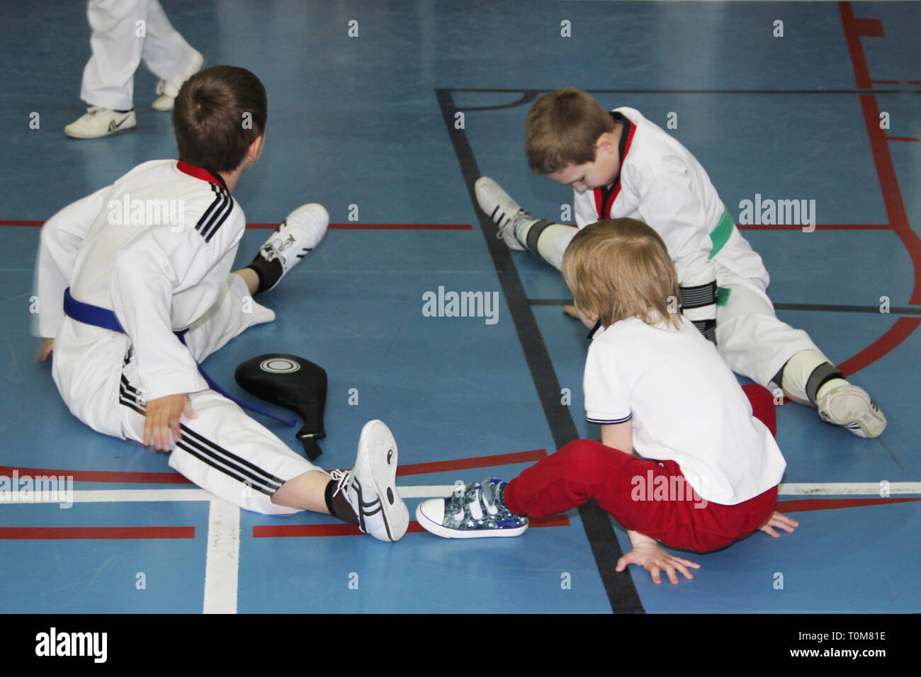 A group of taekwondo sitting on the floor for a rest. Stock Photo