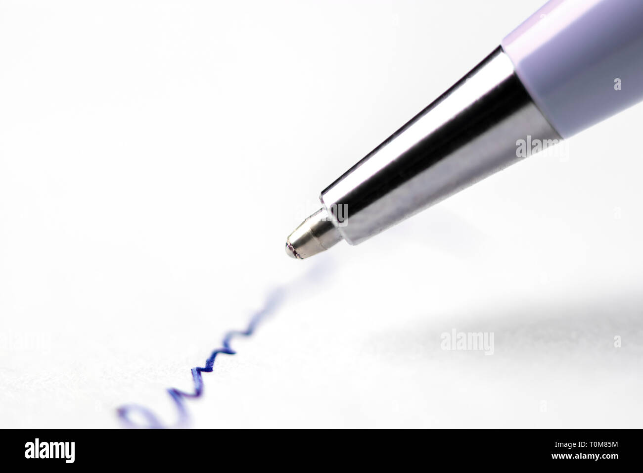Tip of pen writing on paper Stock Photo