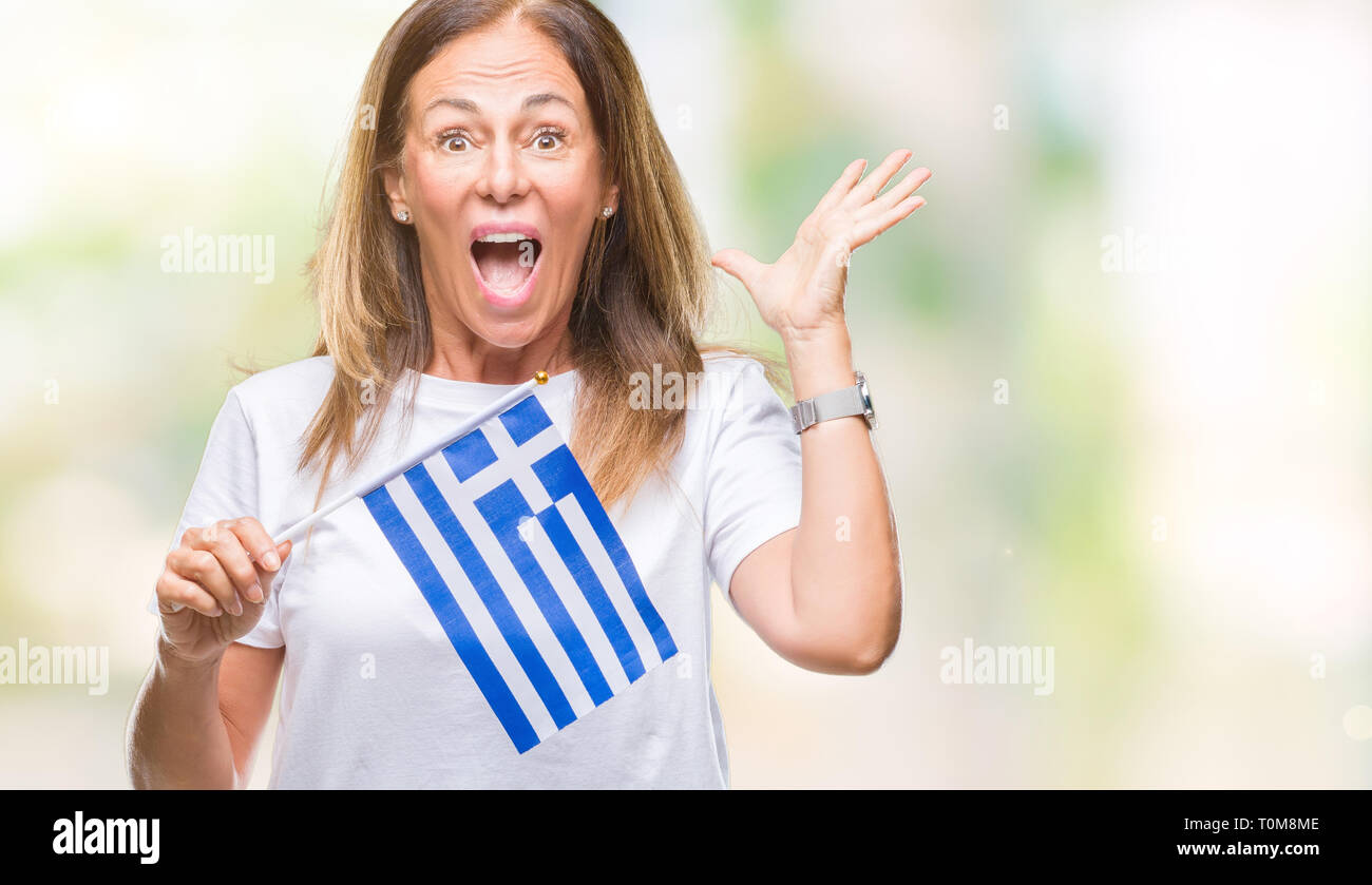 Middle age hispanic woman holding flag of Greece over isolated