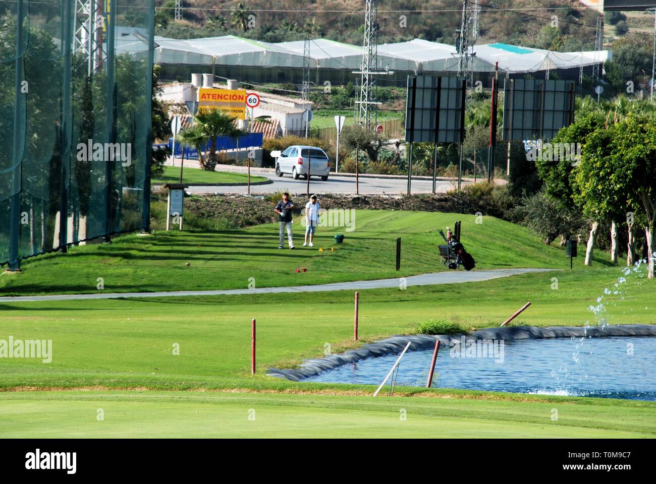 Couple playing golf at Los Llanos de Baviera Golf, Caleta de Velez, Malaga Province, Andalusia, Spain, Western Europe. Stock Photo