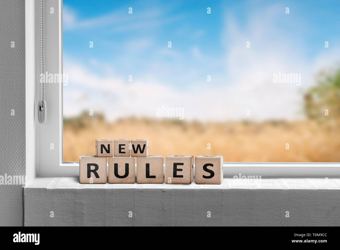 New rules sign in a window with a view to fields under a blue sky Stock