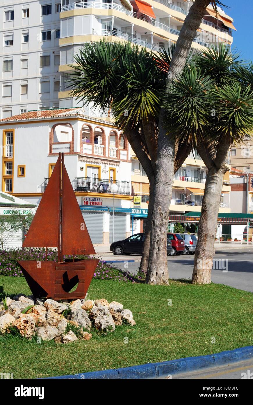 Metal boat sculpture on a traffic island with palm trees to the rear, Torre del Mar, Malaga Province, Andalusia, Spain, Western Europe. Stock Photo