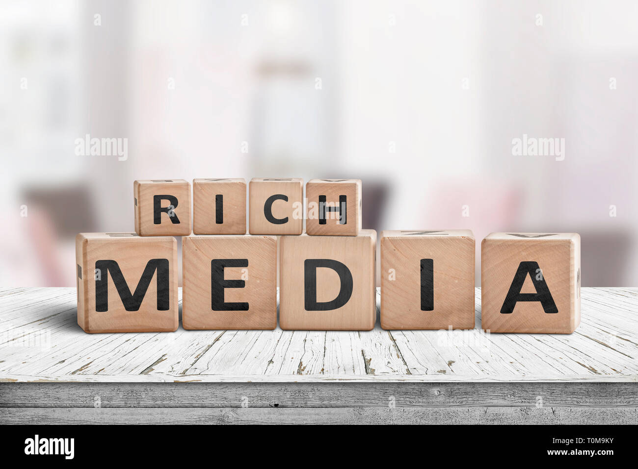 Rich media word sign on a wooden desk in a room in daylight Stock Photo