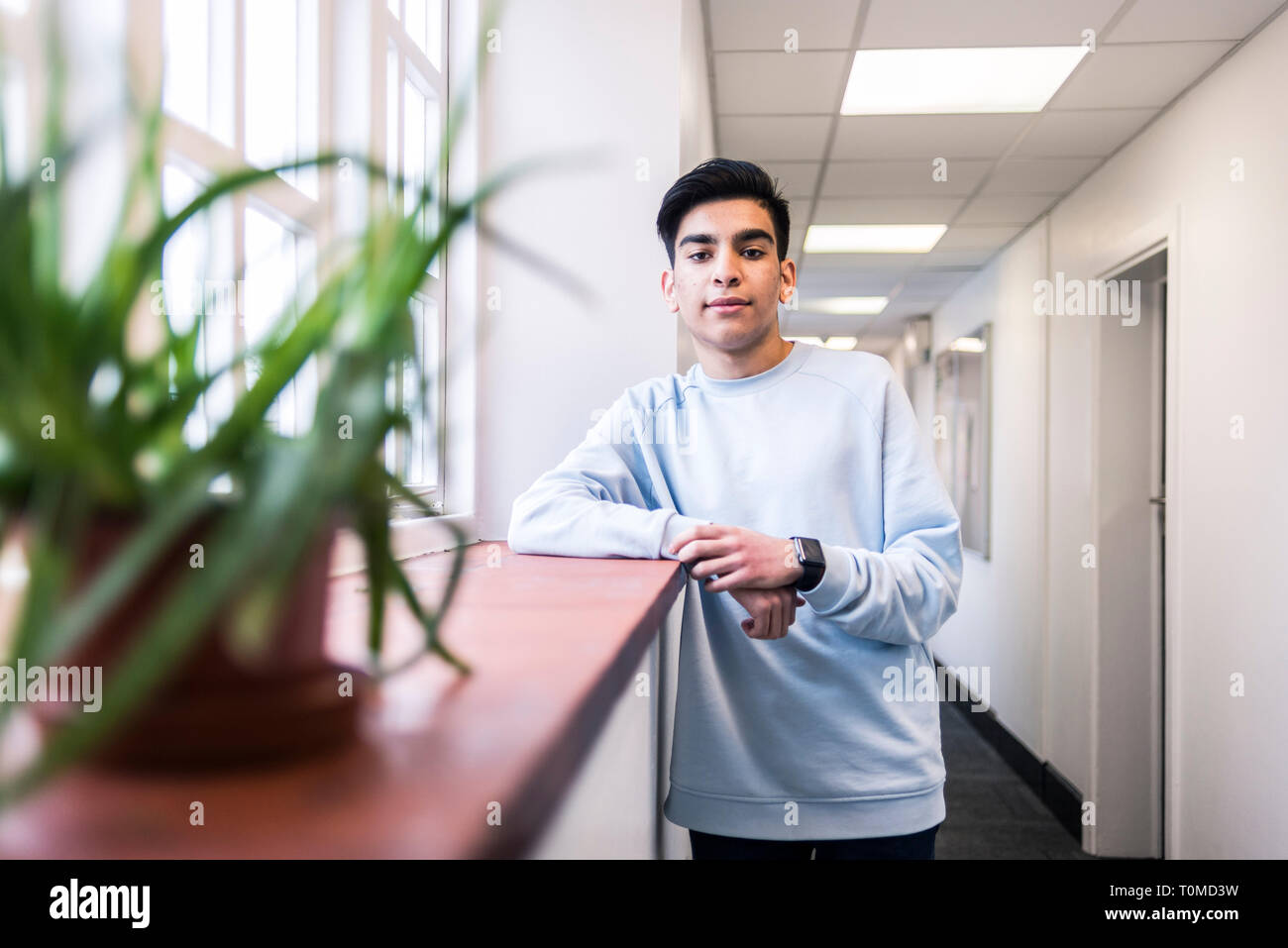 A middle eastern international student stands in the corridors of a cambridge collge Stock Photo